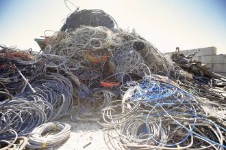 Heap of coiled and tangled cables in scrap metal yard