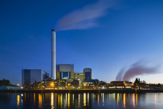 Colorful evening view of a modern waste incineration plant in Oberhausen, Germany with blue sky.